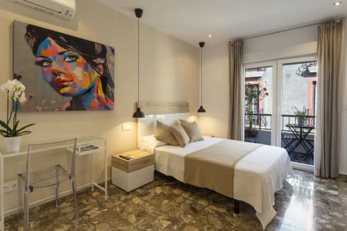 Habitación moderna en Room Boutique 32 de Denia con cama de matrimonio, arte mural colorido, acceso a balcón y vistas a la ciudad