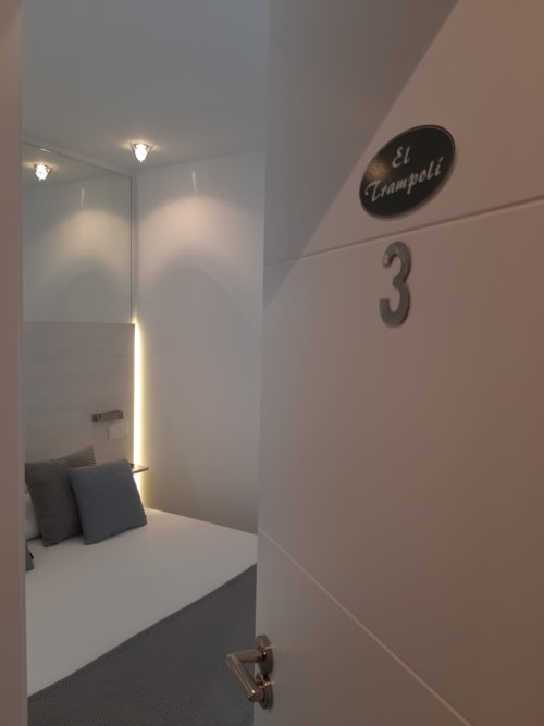 Habitación 3 del hostal el Trampoli en Denia, España - dormitorio moderno con pared espejada e iluminación ambiental
