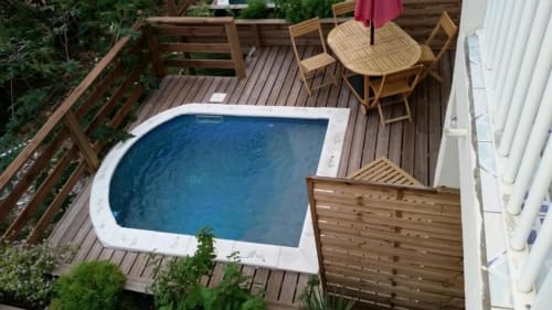 Vue aérienne de la piscine avec terrasse en bois, chaises longues et parasol à Résidence Les 2 Moulins en Guadeloupe