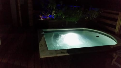 Bain à remous illuminé avec eau bouillonnante la nuit, résidence Les 2 Moulins à Le Moule, Guadeloupe