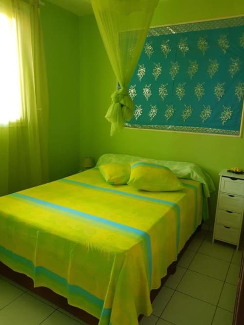 Chambre aux murs vert citron lumineux avec accents turquoise à la Résidence Les 2 Moulins, Guadeloupe