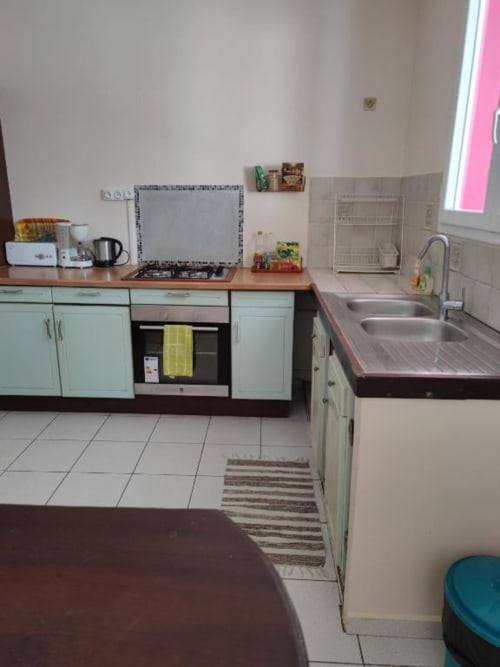 Cuisine moderne de l'appartement Les 2 Moulins, Le Moule, Guadeloupe, avec placards menthe, évier inox, plaque de cuisson