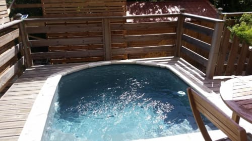 Bain à remous chauffé sur terrasse en bois à la Résidence Les 2 Moulins, Guadeloupe, entouré de balustrades en bois