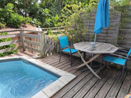Chaises longues bleues et parasol sur la terrasse de la piscine de la Résidence Les 2 Moulins, Le Moule, Guadeloupe