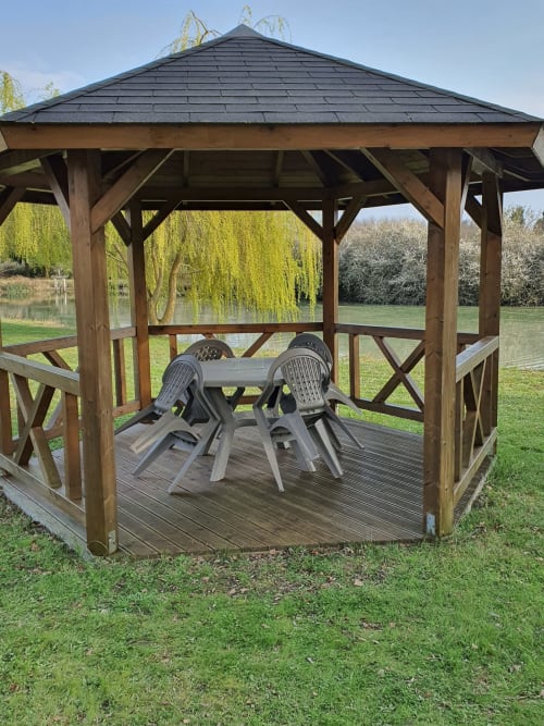 Pavillon en bois avec chaises grises dominant un étang et des saules à l'Hôtel Cheverny La Vie Est Belle, France