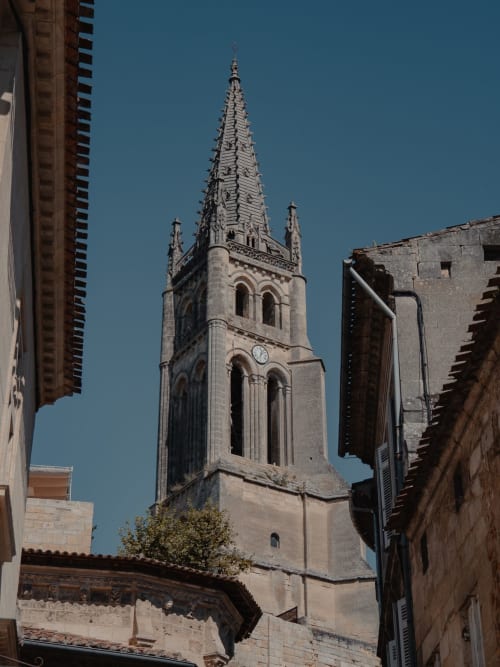 Le clocher historique d'une église s'élève au-dessus des bâtiments en pierre près de Sous Les Marronniers, Petit Palais Cornemps, France