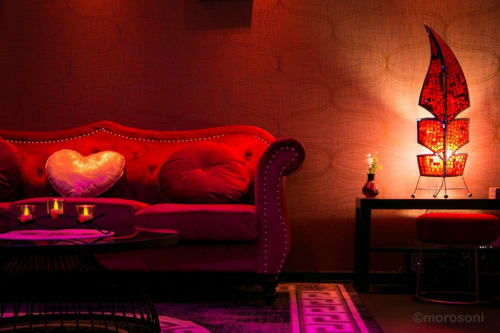 Appartement L'Insolite Spa Privatif Toulouse avec canapé velours rouge, coussin cœur, lampe décorative et éclairage ambiant