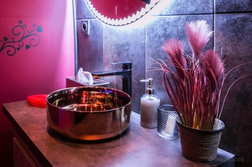 Salle de bain moderne du L'Insolite Spa Privatif à Toulouse avec vasque ronde, mur d'accent rose et herbes de la pampa décoratives
