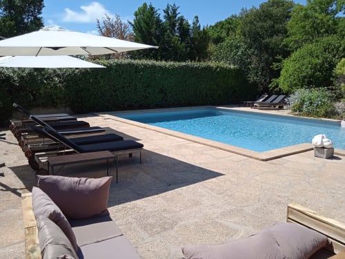 Mas des Artistes pool in Mouriès with loungers, umbrellas, hedges and clear blue water
