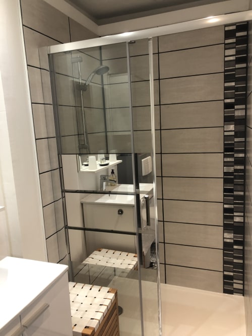 Salle de bain moderne à La Ferme du Bonheur, Arbigny : douche avec portes vitrées et carrelage