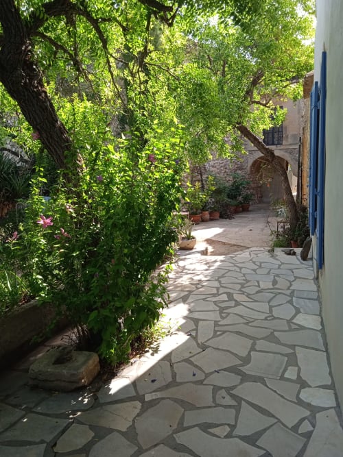 Shaded courtyard with stone pathway at Mas des Artistes, a Provençal bed and breakfast in Mouriès, France.
