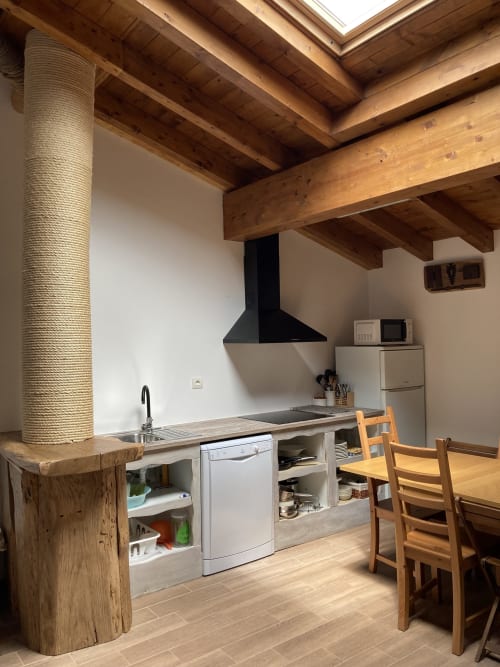Cocina moderna en Apartamentos Casa Lafuente con vigas de madera vista, columna envuelta en cuerda y vistas a las montañas en Lukiano