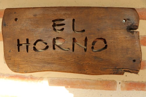 Rústica señalización de madera tallada con 'EL HORNO' en los apartamentos Casa Lafuente de Lukiano, Araba, España