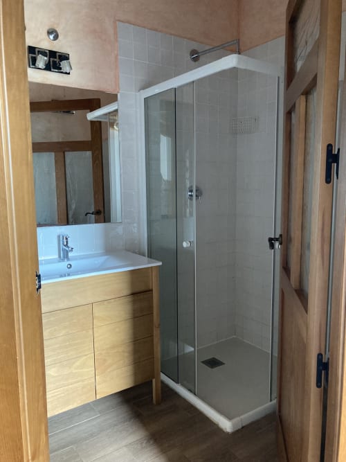 Baño moderno en apartamento Casa Lafuente, Lukiano, Araba con tocador de madera, espejo y ducha con mampara de cristal