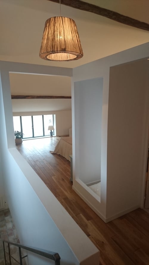 Couloir lumineux et moderne du gîte Mazet 2 au Mas des Artistes à Mouriès, avec parquet et suspension