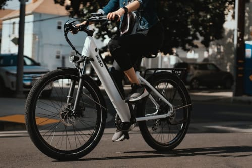 Un client à vélo électrique blanc sur la rue près de la Résidence Les 2 Moulins au Moule, Guadeloupe