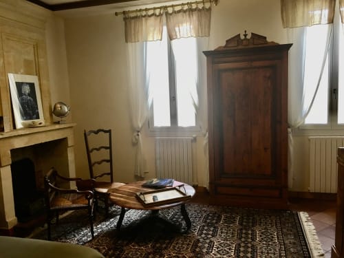 Chambre élégante avec cheminée, mobilier d'époque et lumière naturelle aux Sous Les Marronniers
