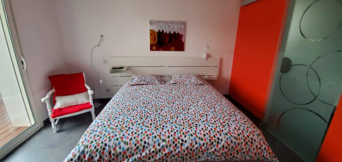 Chambre colorée du Chez Anne Marie B&B à Beausemblant avec literie à motifs et accents rouges