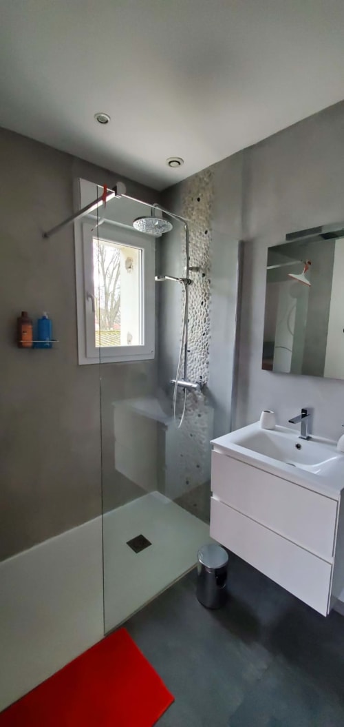 Salle de bain moderne chez Anne Marie avec douche à l'italienne, vasque blanche et vue sur jardin à Beausemblant