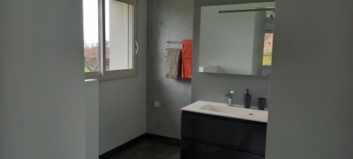 Salle de bain moderne au gîte Chez Anne Marie à Beausemblant avec vasque noire, miroir et fenêtre donnant sur le jardin
