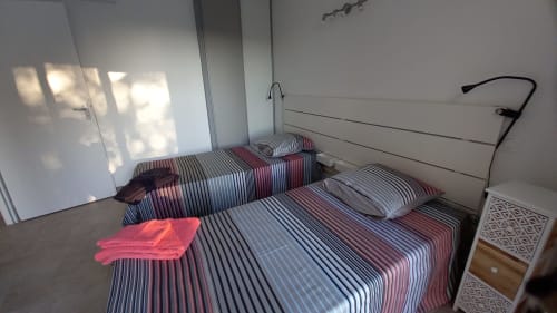 Chambre lumineuse du gîte Chez Anne Marie à Beausemblant avec literie rayée, lumière naturelle et vue sur le jardin