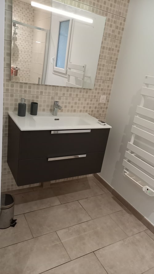 Meuble-lavabo moderne avec armoire noire et vasque blanche au gîte Chez Anne Marie, Beausemblant
