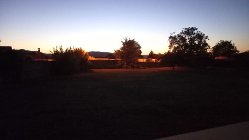 Coucher de soleil sur les jardins du gîte Chez Anne Marie à Beausemblant, ciel doré et arbres