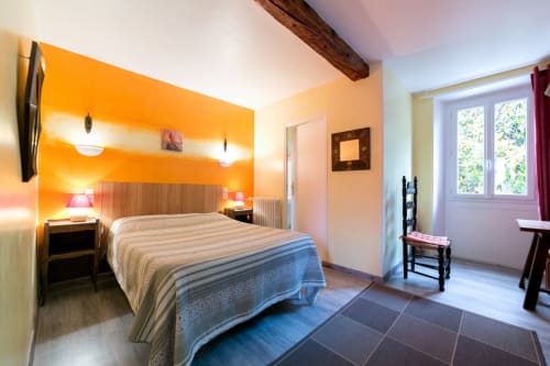 Chambre d'hôtes orange éclatant aux Chambres D'hôtes Les2lions à Vernet-les-Bains avec lit queen-size, vue sur le jardin et décor moderne