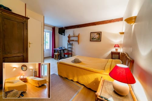 Chambre de l'hôtel Les2lions à Vernet-les-Bains avec lits jumeaux, draps jaunes et vue sur le jardin