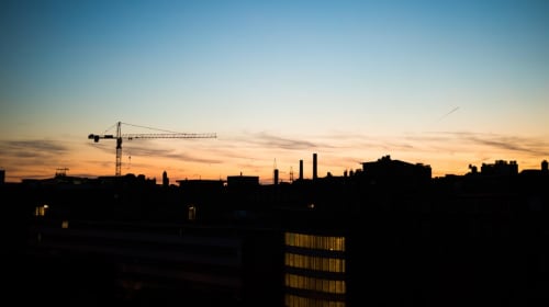 Coucher de soleil sur Marcinelle avec silhouette de grue de construction à la Résidence Mantekila
