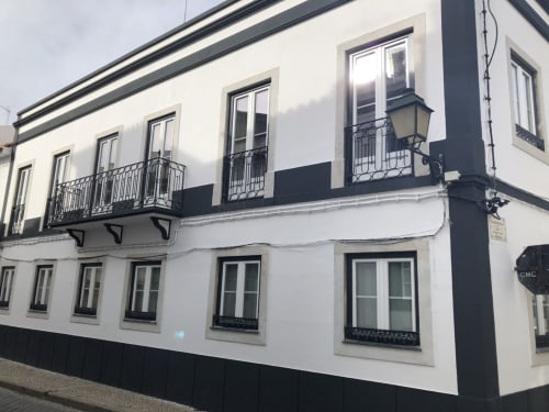 Casa de hóspedes Patio Da Villa em Coruche, Portugal - fachada branca e preta com varandas em ferro forjado e múltiplas janelas