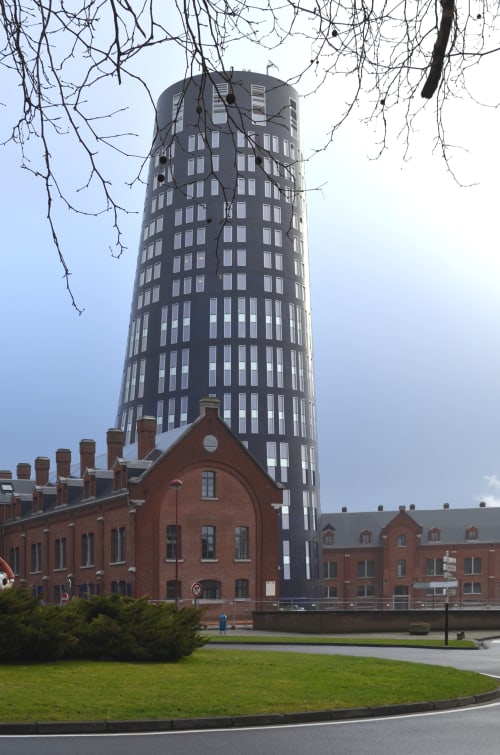 Tour cylindrique moderne avec bâtiments en brique à la Résidence Mantekila, un gîte à Marcinelle, Belgique
