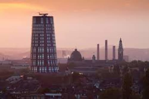 Silhouettes de Marcinelle au coucher de soleil : architecture industrielle et bâtiments historiques se détachant sur un ciel rose
