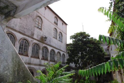 Edifício histórico caiado na pousada Patio Da Villa em Coruche, Portugal, com janelas arqueadas e videiras verdes exuberantes