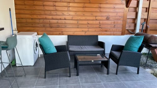 Salon de détente en plein air avec mobilier en rotin noir et coussins turquoise à la villa Kaz A Bibi à Sainte-Rose, Guadeloupe