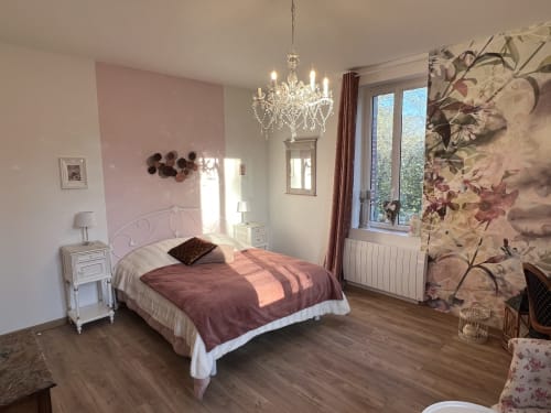 Elegantes Familienzimmer im Château Ségot mit rosa Akzentwand, Kristalllüster und Gartenblick in Neuilly-le-Réal