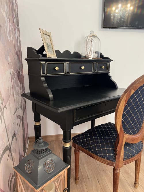 Schwarzer Schreibtisch mit dekorativen Ornamenten im Wohnzimmer des Château Ségot, Neuilly-le-Réal, Frankreich