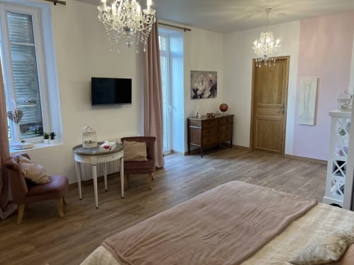Gabrielle-d'Estrées-Zimmer im Château Ségot in Neuilly-le-Réal mit Bett, Sitzbereich, Fernseher und Kristalllüstern