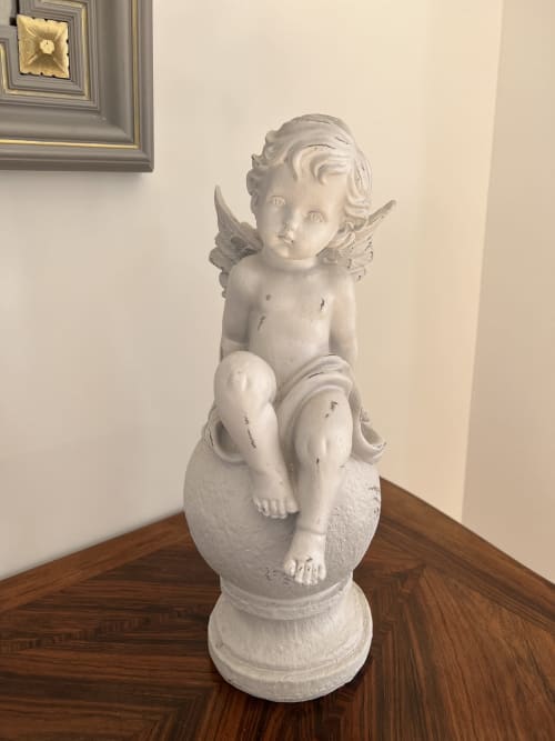 Weiße geflügelte Cherubstatue auf Sockel im Gabrielle-Robinne-Zimmer des Château Ségot, Neuilly-le-Réal