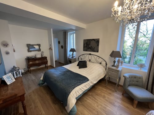 Gabrielle-Robinne-Zimmer im Château Ségot in Neuilly-le-Réal mit Schmiedeeisenbett, Gartenblick, Kronleuchter und Eleganz