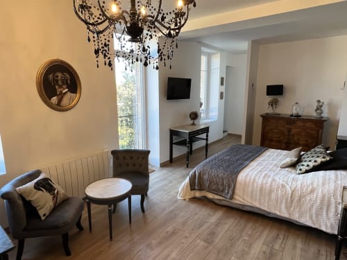 Gabrielle-Chanel-Zimmer im Château Ségot, Neuilly-le-Réal: elegantes Schlafzimmer mit Kronleuchter, Bett, Sitzbereich und zeitgemäßer Einrichtung