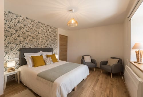 Chambre moderne à La Vallee Joly B&B au Vast, France, avec papier peint floral, lit queen et coin salon