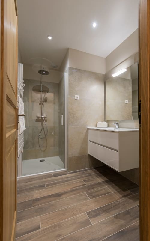 Salle de bain moderne à La Vallee Joly B&B au Vast, France avec douche à l'italienne, vasque blanche et sol imitation bois