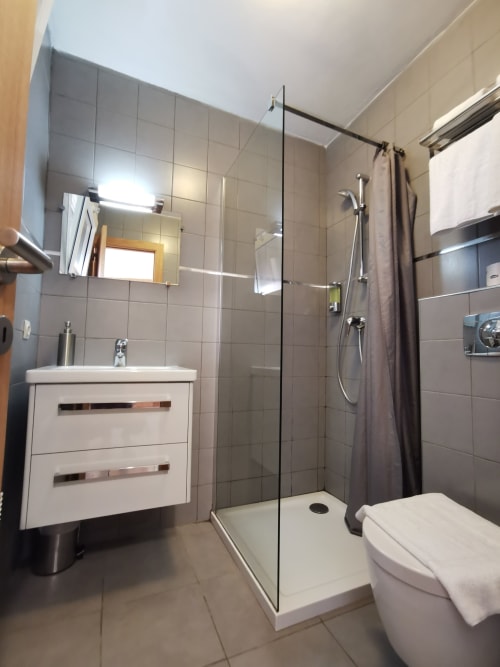 Salle de bains moderne à la Résidence Saint Michel à L'Île-Rousse avec douche à l'italienne, vasque blanche et murs carrelés