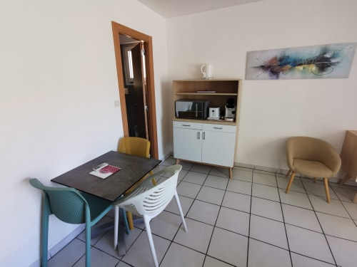 Kitchenette moderne et coin repas à la Résidence Saint Michel, L'île Rousse avec table, chaises colorées et rangements