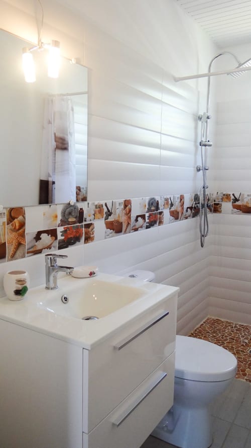 Salle de bain moderne à la Villa Tourmaline avec lavabo blanc, douche et frise décorative côtière à Le Lorrain, Martinique