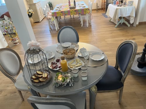 Table ronde élégante dressée pour le petit-déjeuner au Château Ségot B&B à Neuilly-le-Réal avec viennoiseries et service de boissons