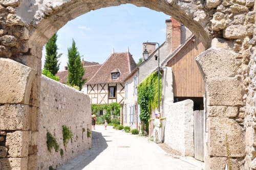 Stone archway entrance to medieval village street at Château Ségot B&B, Neuilly-le-Réal France