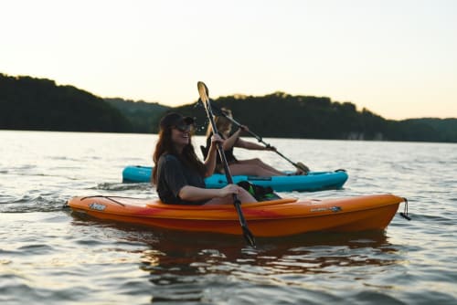 Femme en kayak sur le lac près du Château Ségot, Neuilly-le-Réal, profitant des activités nautiques en plein air