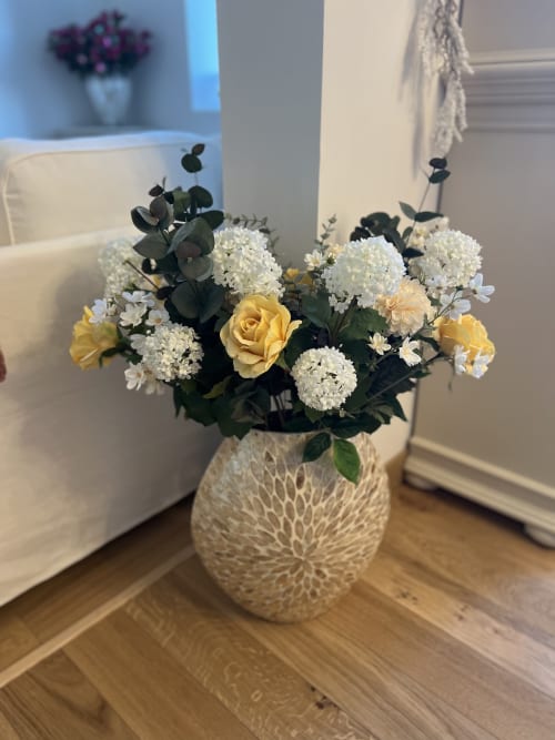 Elegant floral arrangement with white hydrangeas and yellow roses in a textured vase at Château Ségot, Neuilly-le-Réal